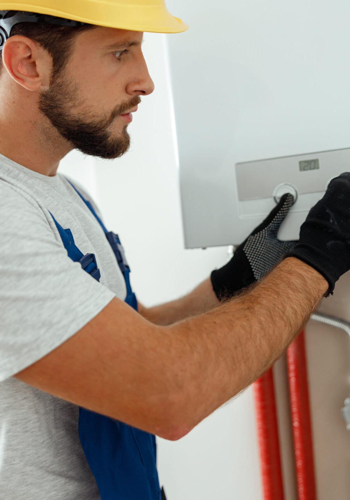 Serious technician setting the new gas boiler for hot water and heating. Manual work, maintenance concept
